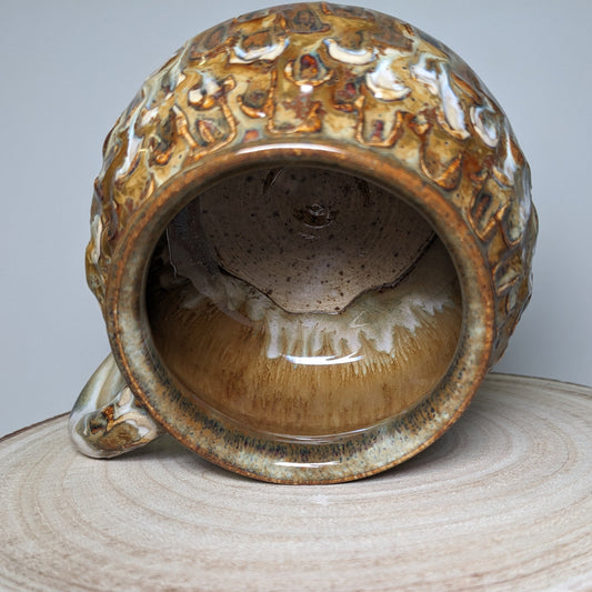 Håndlaget keramisk kopp i karamell- og kremtoner