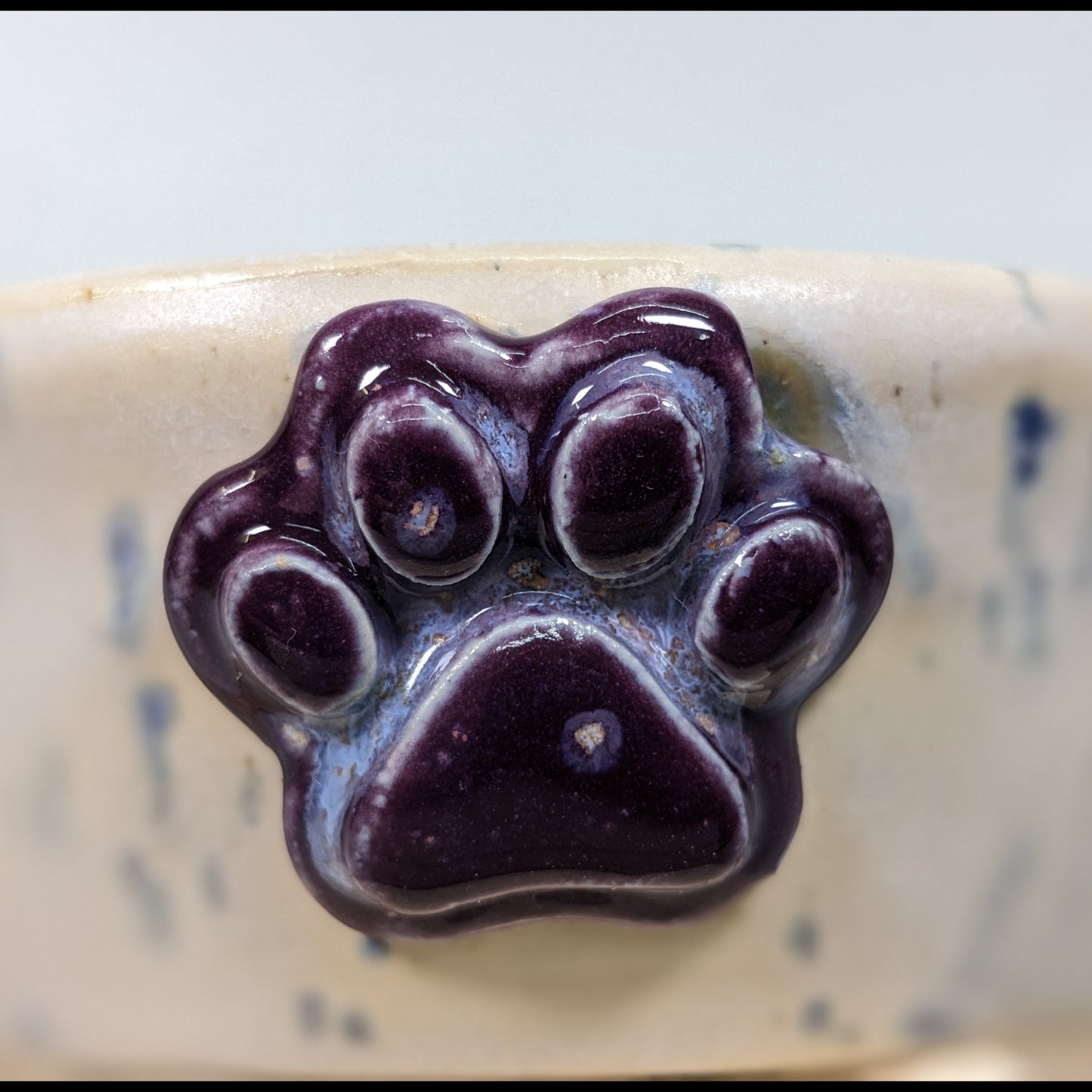 Keramikkskål i elfenben og lavendel med lilla poteavtrykk